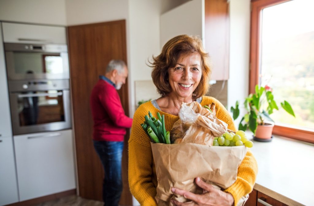 An older couple bringing in groceries from a trip to the store