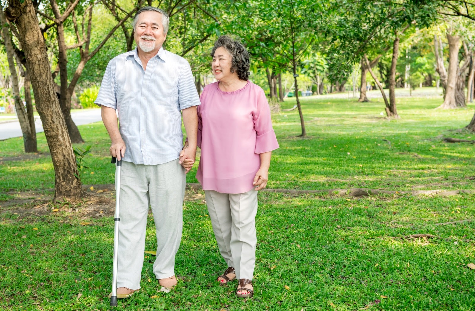 An older couple supporting each other while they are on a walk