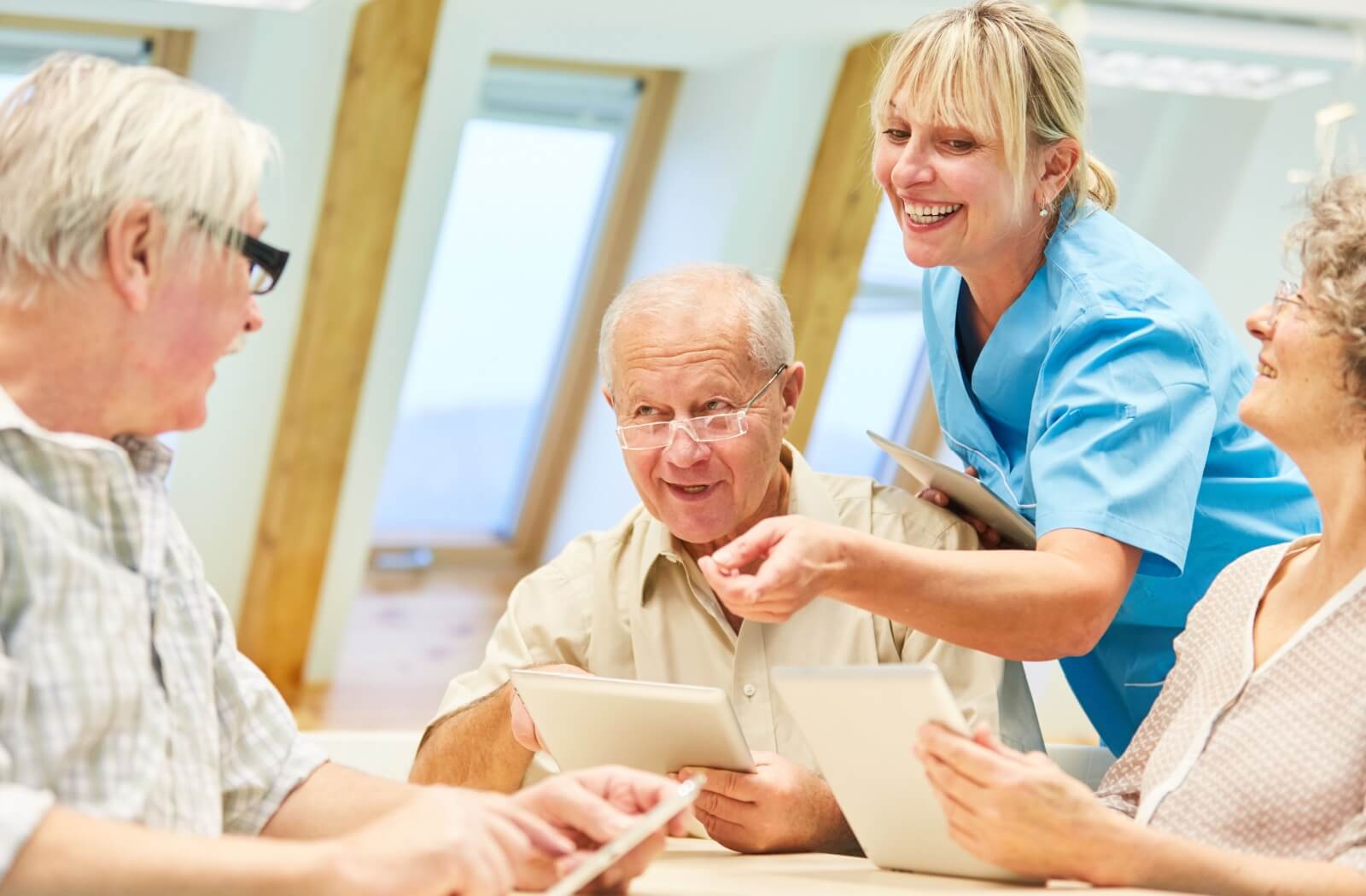 A young staff member is interacting with 3 residents while in respite care.