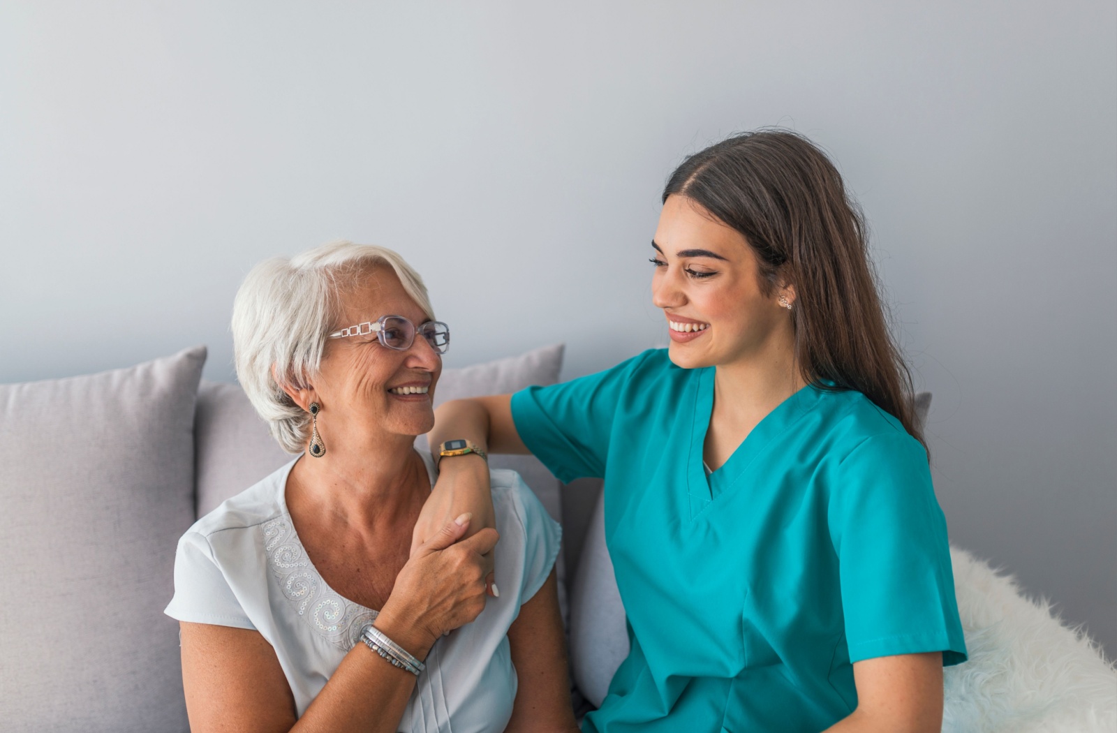 Senior sitting with a healthcare professional receiving personalized on-site healthcare in an assisted living community.
