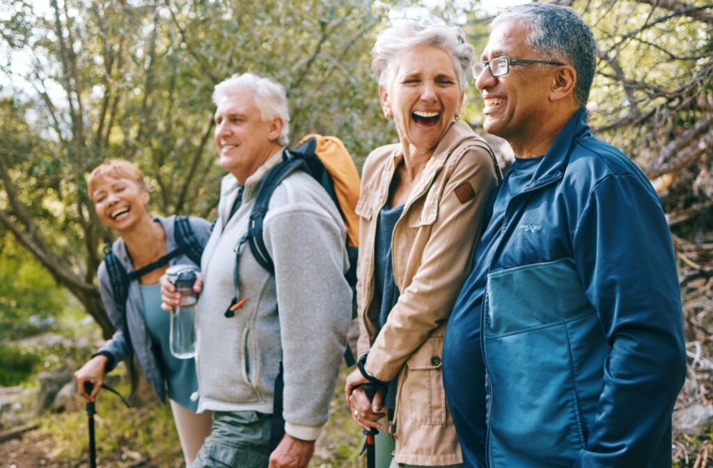 Group of seniors smiling and laughing while hiking, enjoying exercise to support strong bones.